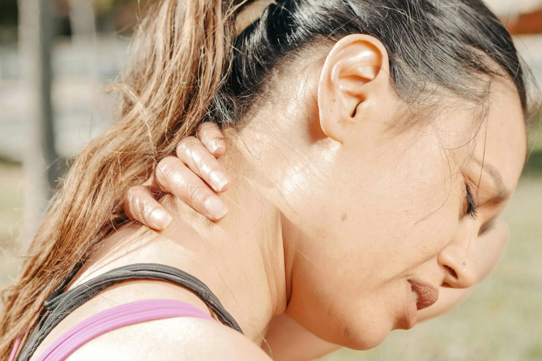 An adult holding the side of the neck